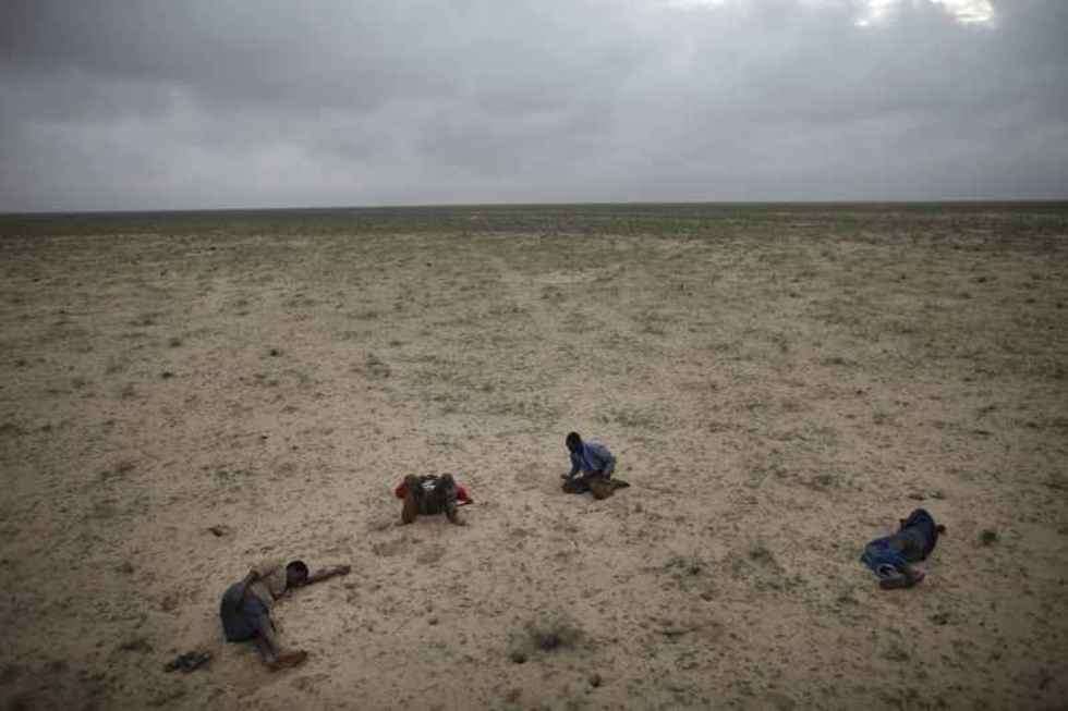  1st Prize Contemporary Issues Stories 
Escape from Somalia, March:
Four Somali refugees en route to Yemen sleep in the desert after traveling all night on muddy roads and in pouring rain, Somaliland, 15 March.