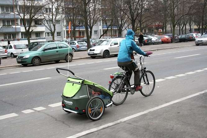 Zima wcale nie przeszkadza Berlińczykom w korzystaniu z rowerów. W przyczepce ciągniętej przez kobietę na rowerze siedzi małe dziecko