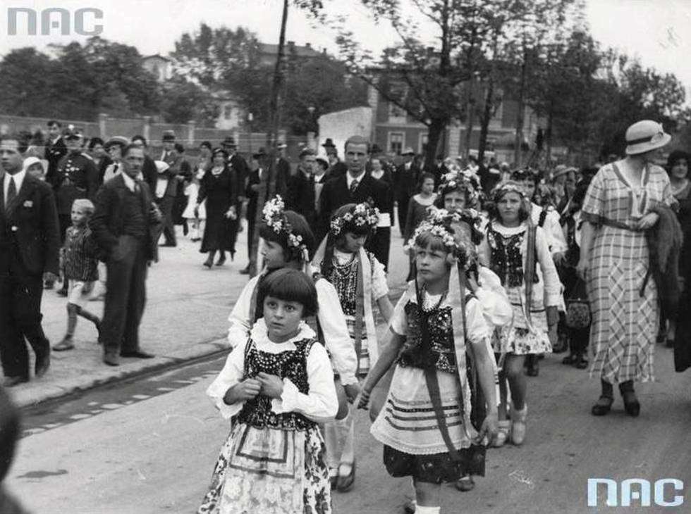  Kolejne ujęcie z pochodu z okazji Święta Wiosny. Dziewczynki w strojach krakowskich idą przez miasto.