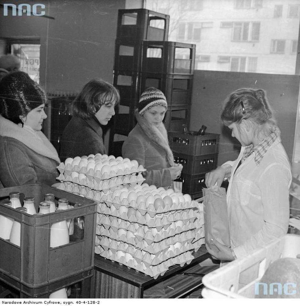  Stoisko z pieczywem i nabiałem. Ekspedientka pakuje do papierowej torebki jajka. 

Data wydarzenia: 1967 - 1982 
