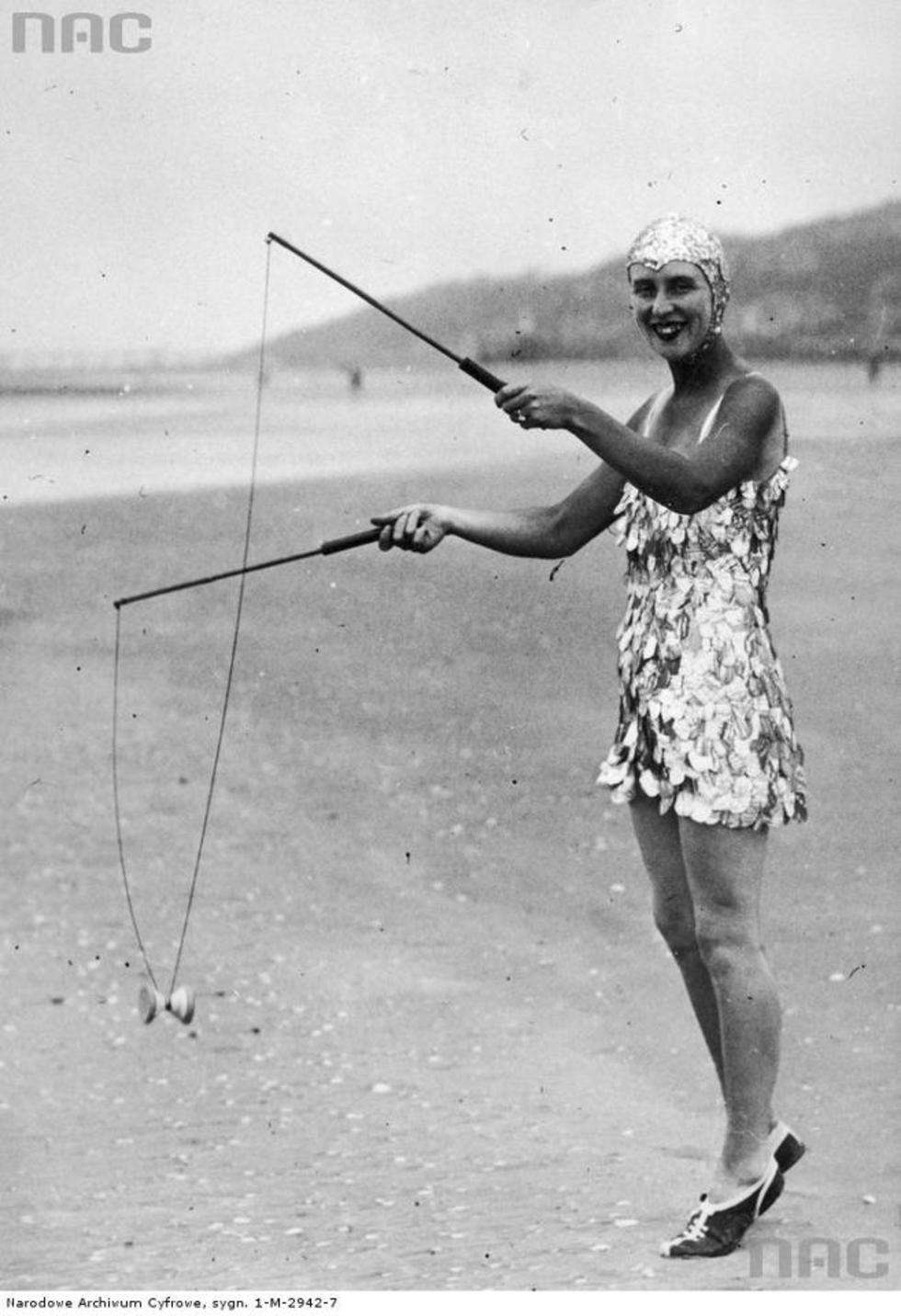 Kobieta na plaży w oryginalnym stroju kąpielowym z łusek i czepku