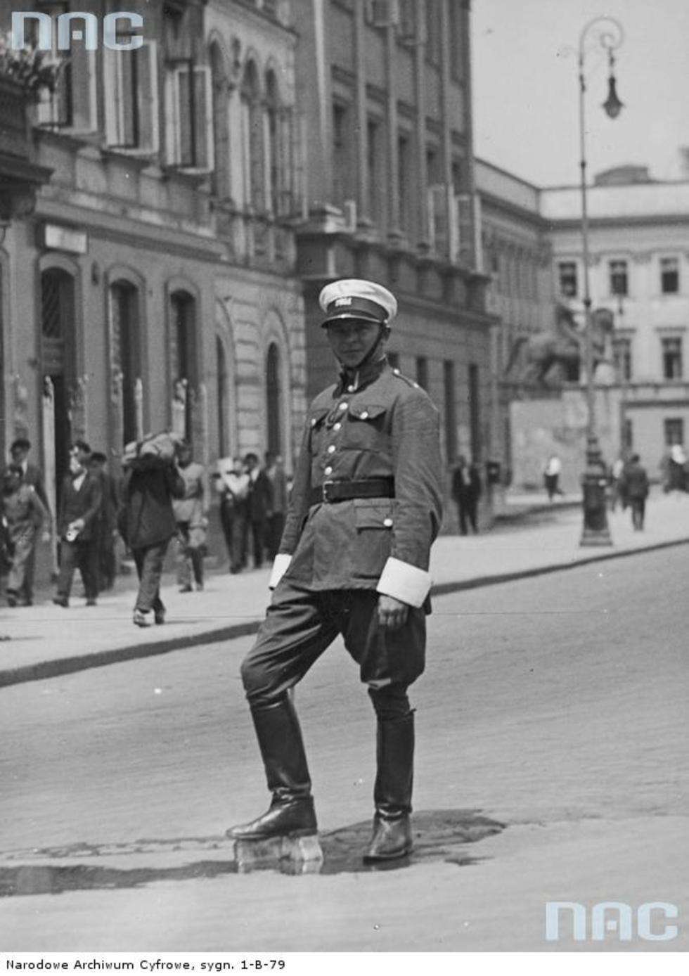  Lipiec 1932 r. Policjant kierujący ruchem na placu Marszałka Józefa Piłsudskiego chłodzi nogi od upału stawiając je na bloku lodowym. W głębi widoczny pomnik księcia Józefa Poniatowskiego.
