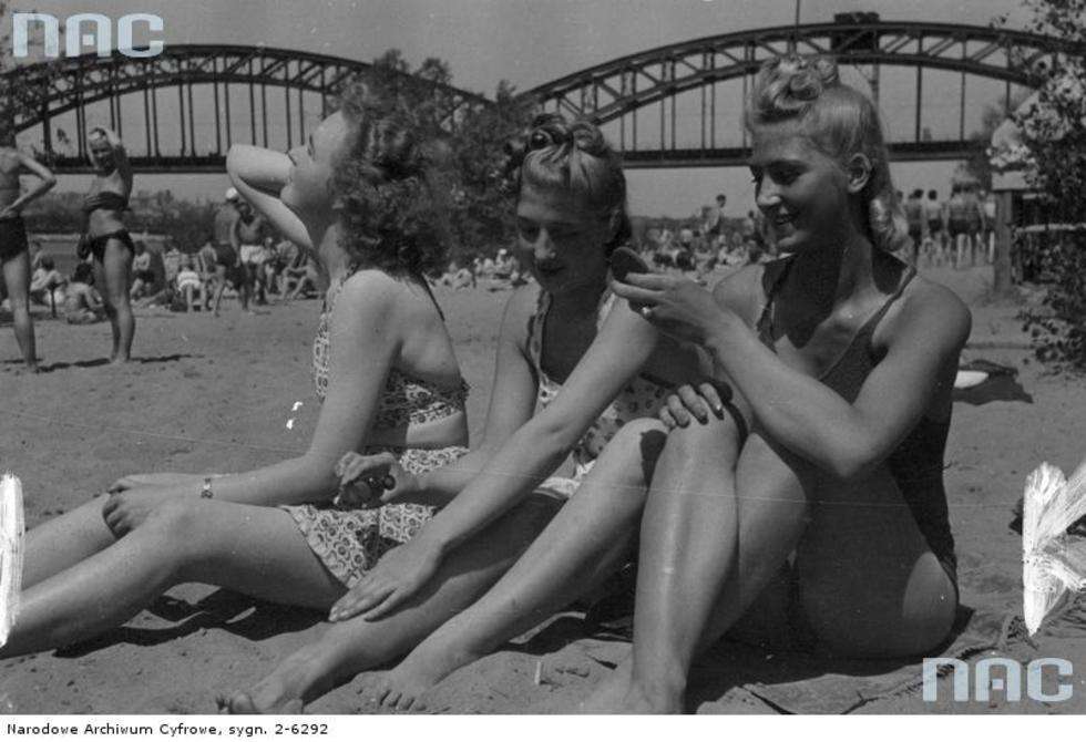  Plaża nad Wisłą przy moście średnicowym. Trzy kobiety siedzą na ręczniku.
