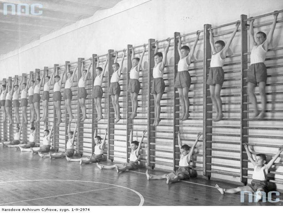  Rok 1938. Lekcja gimnastyki. Chłopcy podczas ćwiczeń na drabinkach. Miejsce nieznane.