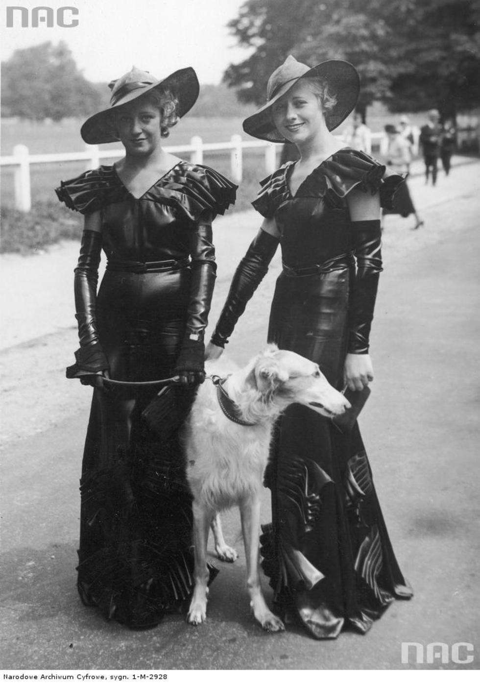  Konkurs elegancji w Paryżu. Kobiety w eleganckich sukniach z aplikacjami i marszczeniami, kapeluszach oraz chartem na smyczy podczas konkursu mody. Czerwiec 1933 r.

