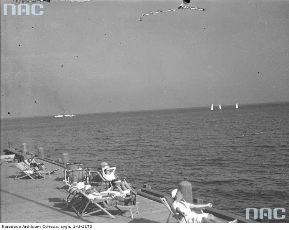   Plażowicze podczas wypoczynku na molo nad morzem Bałtyckim w Gdyni.  1936 r.

Fot. <a href="http://img.audiovis.nac.gov.pl/PIC/PIC_1-U-1173.jpg">NAC</a>

