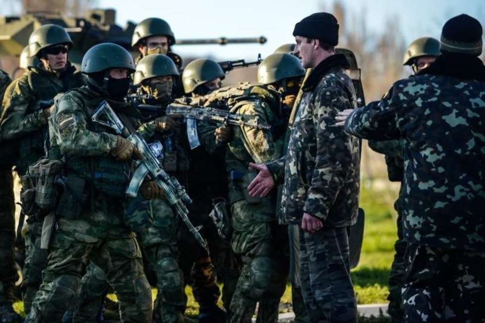  <b>Zdjęcie pojedyncze - zwycięzca w kategorii WYDARZENIA</b><br /><br />Krym. Ukraińska baza wojskowa Belbek po szturmie rosyjskich wojsk specjalnych poddała się. Na zdjęciu widać nieuzbrojonych ukraińskich żołnierzy, którzy od referendum bronili bazy, odpierając ataki prorosyjskich prowokatorów. Po przejęciu bazy przez Rosjan dziennikarzy zmuszano, by oddali wszystkie materiały, które rejestrowały ich szturm. Dzięki szybkiemu skopiowaniu i ukryciu karty zdjęcie ocalało. 22 marca 2014<br /><br />