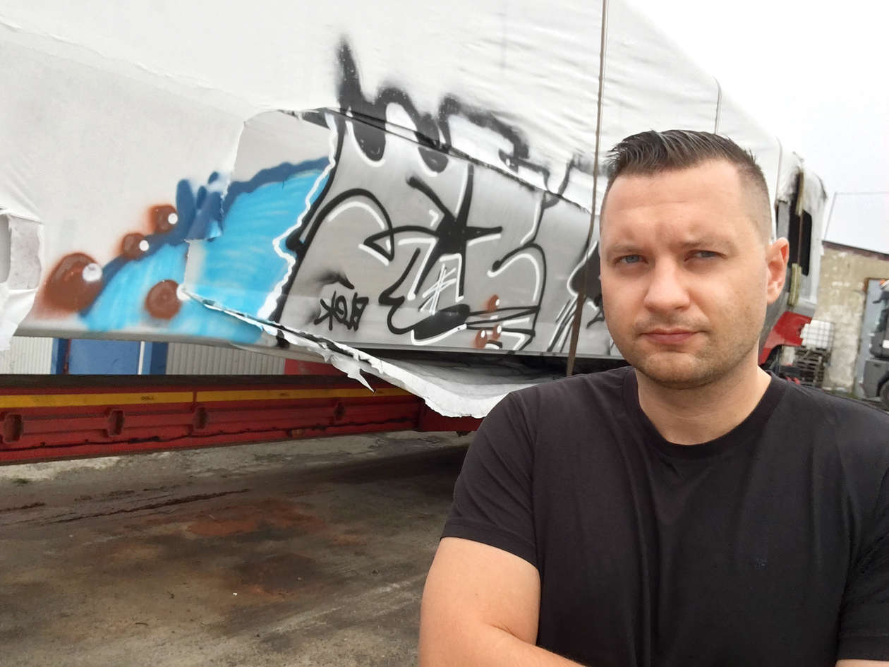  <p>Michał Woch, wsp&oacute;łwłaściciel Focus Truck Special Transport na tle uszkodzonego wagonu</p>