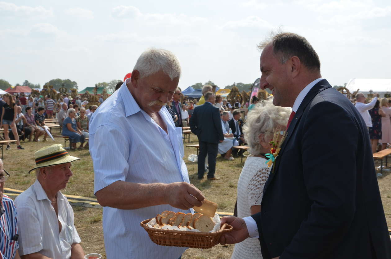  <p>Wicemarszałek Grzegorz Kapusta dzieli się chlebem z uczetnikami dożynek</p>