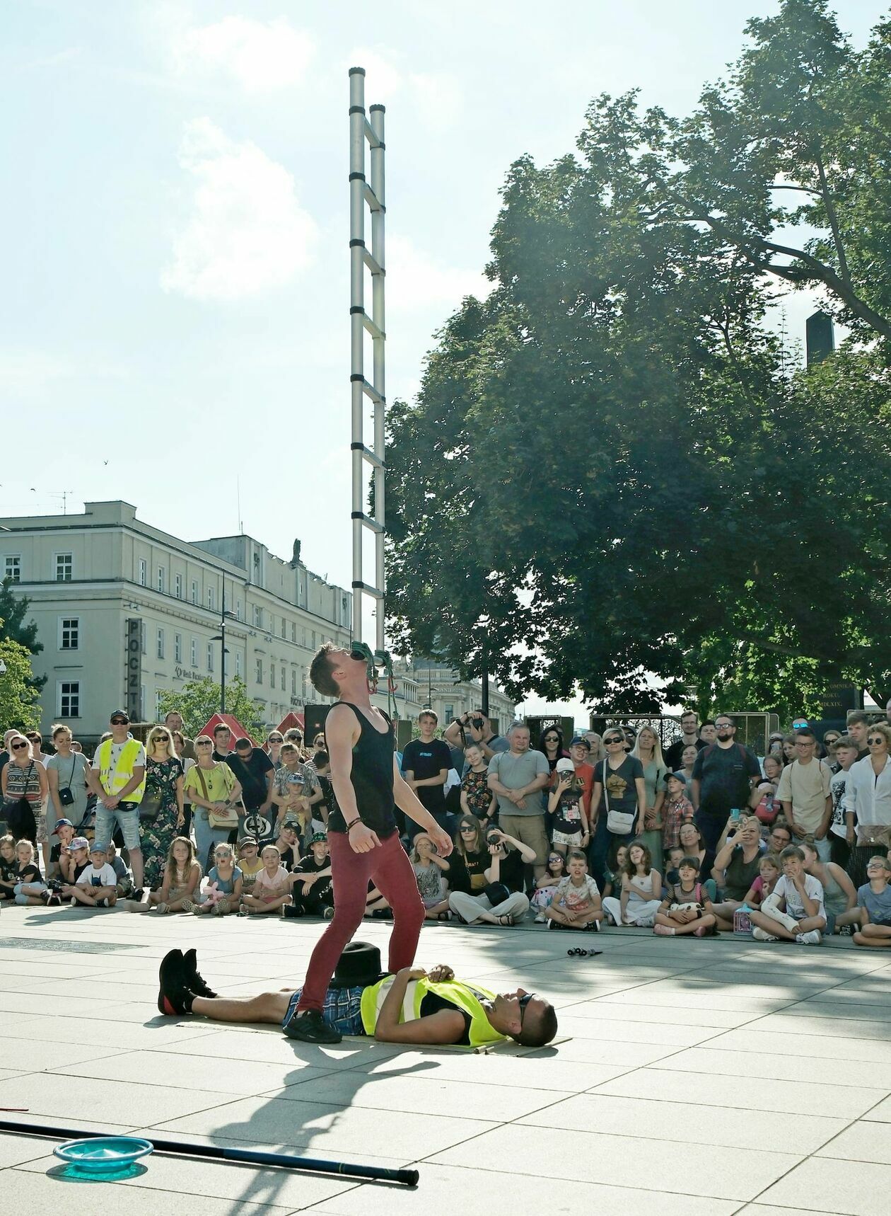  <p>Busker spaceruje&nbsp;z drabiną balansującą na brodzie przez plac Litewski</p>