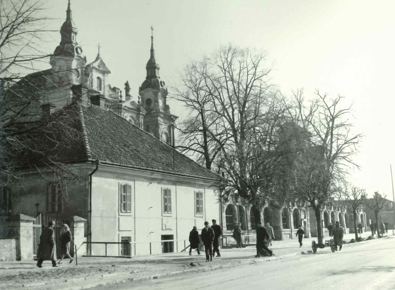  <p>Lubart&oacute;w, widok na plebanię i ogrodzenie kościelne z kościołem w tle od ul. Słowackiego</p>