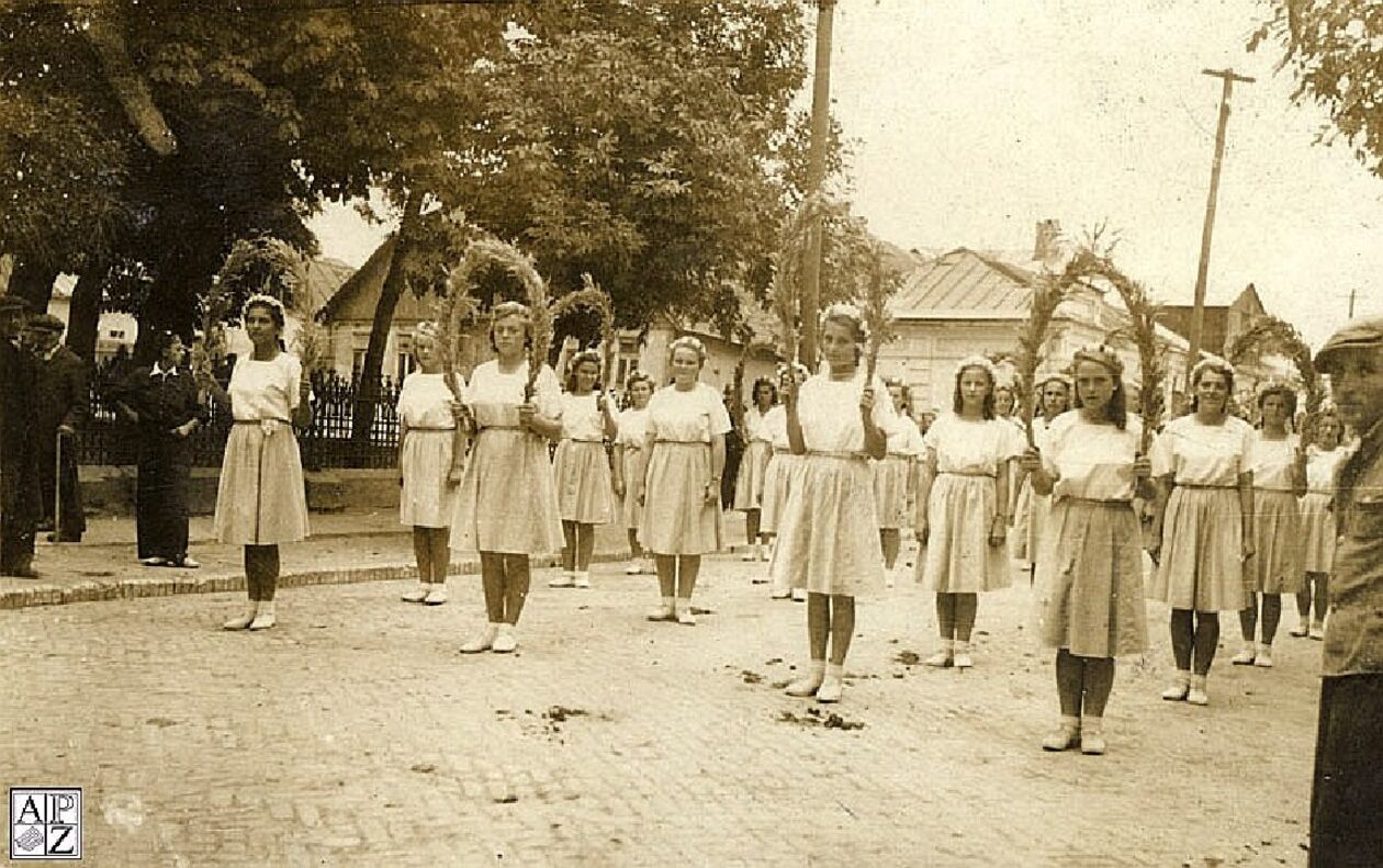  <p>Ulica 3 Maja - dożynki w 1949 r. Po lewej metalowe ogrodzenie przy hrubieszowskiej cerkwi.</p>