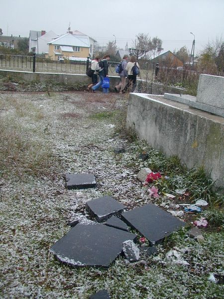 Widok zdewastowanego pomnika i wyłamanych przęseł cmentarza nie uczy przechodzących obok młodych lud