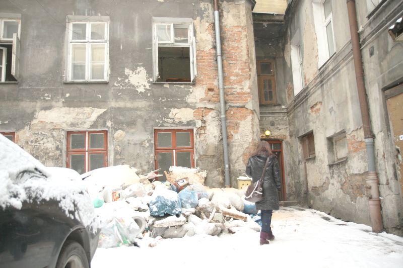 Na podwórku kamienicy leżą stosy gruzu i innych odpadów z remontowanych lokali. (Maciej Kaczanowski)