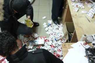 Odebrane przemytnikom paczki papierosów są na przejściu w Dorohusku skrupulatnie liczone i układane 