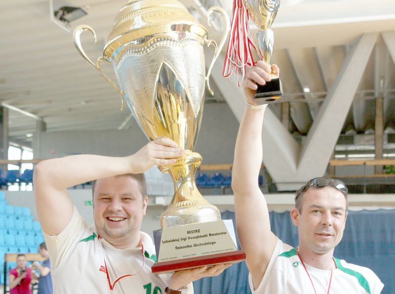 Łukasz Mrozik (z lewej) unosi puchar za zdobycie mistrzostwa rozgrywek Pod koszami Dziennika Wschodn