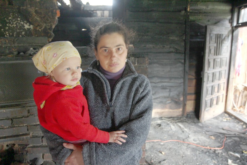 Anna Drabik z dwuletnią wnuczką Adą w spalonym domu (Maciej Kaczanowski)