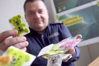 Młodszy inspektor Sławomir Góźdź prezentuje samoprzylepne odblaskowe misie. (Jacek Świerczyński)