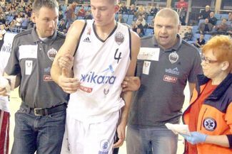 Patryk Pełka (w białym stroju) opuszczał boisko przy pomocy członków sztabu szkoleniowego (JACEK ŚWI