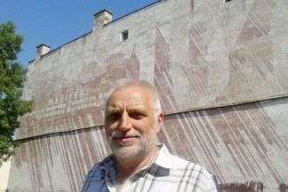 Jerzy Masłowski na tle malowidła upamiętniającego Manifest PKWN na ścianie kamienicy przy ul. Lubelskiej w Chełmie (Fot. Jacek Barczyński)