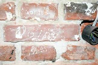 „Koniec wojny”, jedna z inskrypcji odkrytych na murze dawnej celi, w piwnicy WKU (fot. Radosław Szczęch)