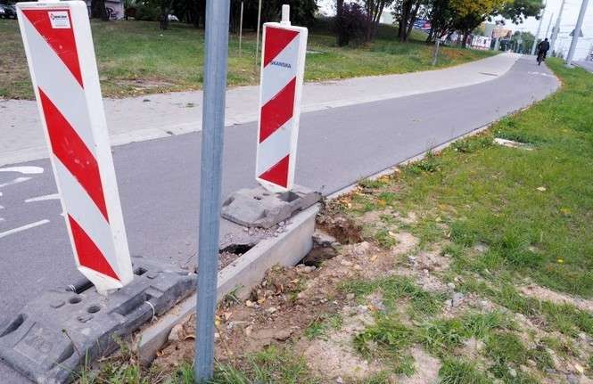 Dziura w trasie dla rowerzystów wciąż jest zabezpieczona tylko biało-czerwonymi słupkami (fot. Dorota Awiorko)
