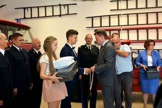 Kinga z Rejowca Fabrycznego i Szymon z Parczewa odbierają nagrody od ministra Mariusza Błaszczaka. Uroczystość odbyła się w Muzeum Pożarnictwa w Oseredku (gm. Susiec)

