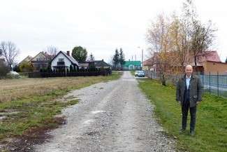 Wójt Wiesław Kociuba przy drodze na przebudowę której gmina właśnie otrzymała dofinansowanie (fot. Urząd Gminy Chełm)