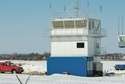 Istniejąca wieża ma trzy kondygnacje i zbudowana jest z sześciu kontenerów. Z prawej – mobilna wieża, której używano w pierwszej fazie funkcjonowania lotniska
