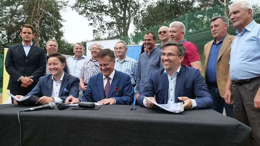 Podpisanie umowy, od lewej: Lech Wąsowki z Warbudu, Waldemar Jakson, burmistrz Świdnika i Wojciech Gerber z Warbudu. Za nimi stoją miejscy radni