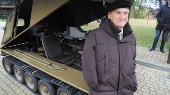 Płk Zbigniew Węglarz na tle odtworzonego przez studentów trenażera