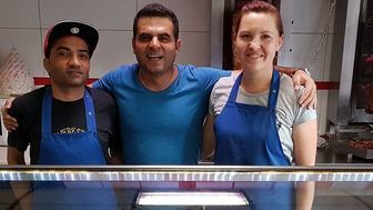 Właściciel baru (w środku) zaprasza bezdomnych na kanapkę