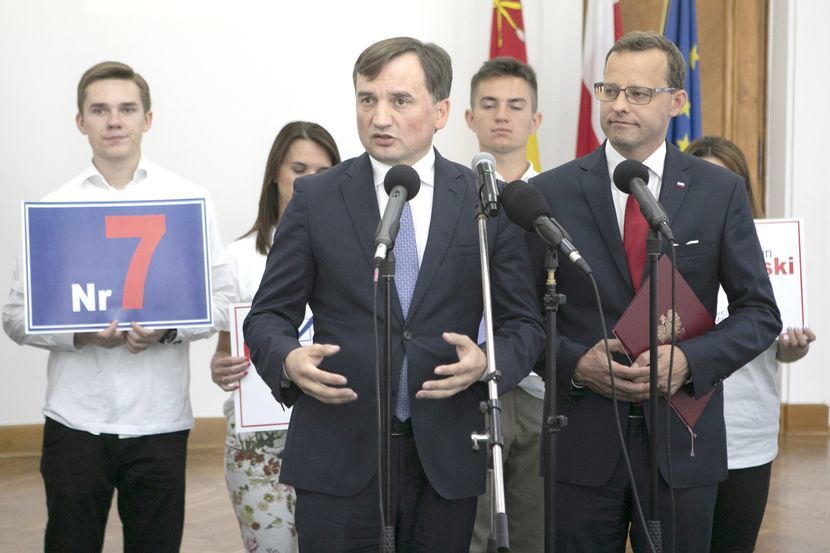 Za ministrami stali młodzi ludzie w koszulkach z logo PiS i numerem Romanowskiego na liście wyborczej