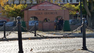 Prostokątna budowla dwuizbowa z dostawką (prawdopodobnie dawny ratusz z wieżą zegarową) znajduje się w centralnej części placu – między Pomnikiem Kraśnickiej Cegły a drogą

 