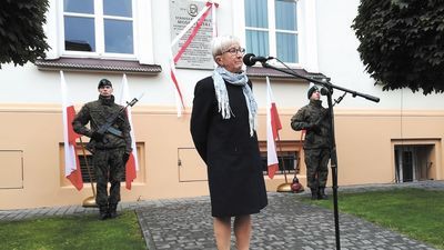 Maria Klimkowska, wnuczka Stanisława Moskalewskiego, na tle tablicy poświęconej jej dziadkowi