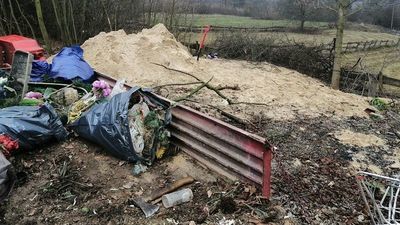 Trzech mężczyzn na terenie przyległym do kościoła wyrzucało śmieci, które przysypywali piachem