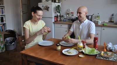 Kasia i Dawid wspólnie jedzący wegańskie burgery przygotowane przez Dawida. Taki posiłek kosztował 10 zł
