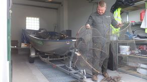 Komendant Paweł Stolarczyk pokazuje przejęte kłusownicze więcierze, sieci i zastawiane na strażników pułapki 