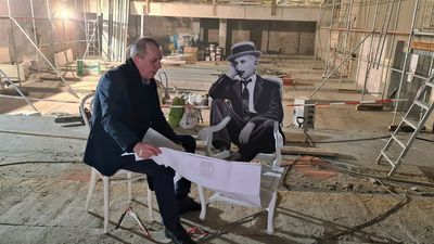 Poeta Bolesław Leśmian i Janusz Nowosad, dyrektor ZDK zatopieni w rozmowie, siedzą w remontowanej sali widowiskowej domu kultury 