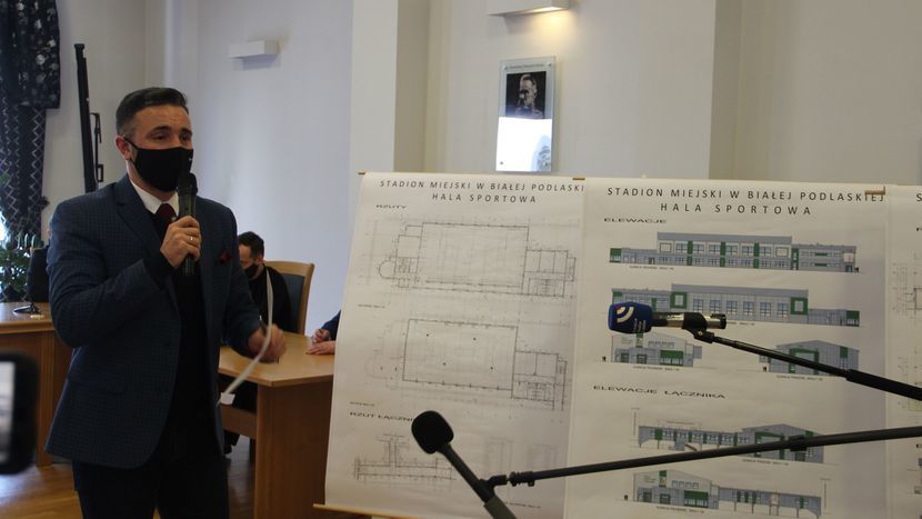 Prezydent Białej Podlaskiej Michał Litwiniuk na tle wizualizacji przebudowy stadionu