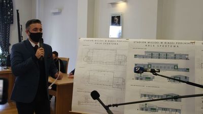 Prezydent Białej Podlaskiej Michał Litwiniuk na tle wizualizacji przebudowy stadionu podczas konferencji 29 stycznia 