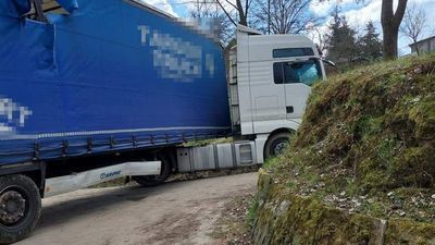 Uszkodzone dachy budynków i naczepa, zablokowana droga i tysiąc mandatu. Bo zaufał nawigacji