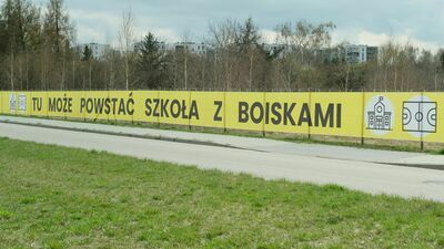 Banner odsyłający do specjalnej strony internetowej zawisł na ogrodzeniu nieruchomości, którą spółka miałaby sprzedać miastu pod budowę szkoły