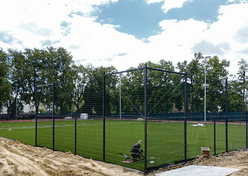 Aktualnie na placu budowy trwają m.in. prace przy układaniu sztucznej trawy na boisku piłkarskim