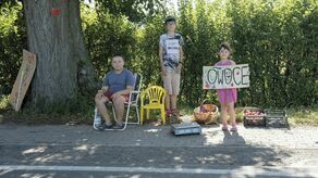 Kuba, Paweł i Wiktoria na stoisku z owocami, które wcześniej sami zebrali