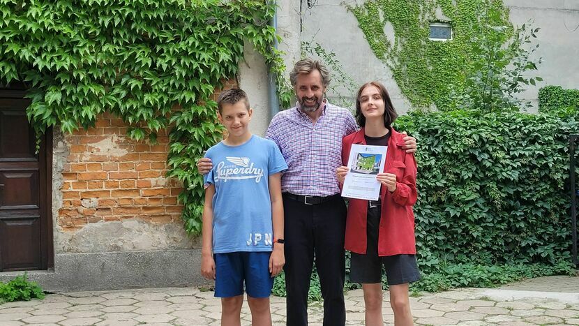 Seweryn Szczepaniak z Jankiem i Emilką, trzymającą dyplom Skarbu Kultury Przestrzeni, na podwórku przy Peowiaków 10<br />

