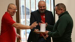 Ks. Władysław Łukasiewicz odbierający dyplom z pisemnym podziękowaniem od liderów kazimierskiego stowarzyszenia.