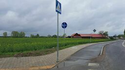 Znak „przejście dla pieszych” pośrodku ścieżki rowerowej i chodnika