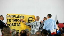W trakcie wystąpienia premiera na scenę weszło dwóch aktywistów z adresowanym do niego transparentem