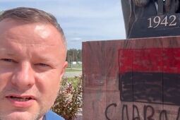 Zdewastowany pomnik ofiar ludobójstwa na Wołyniu. Czerwono-czarna flaga i napis